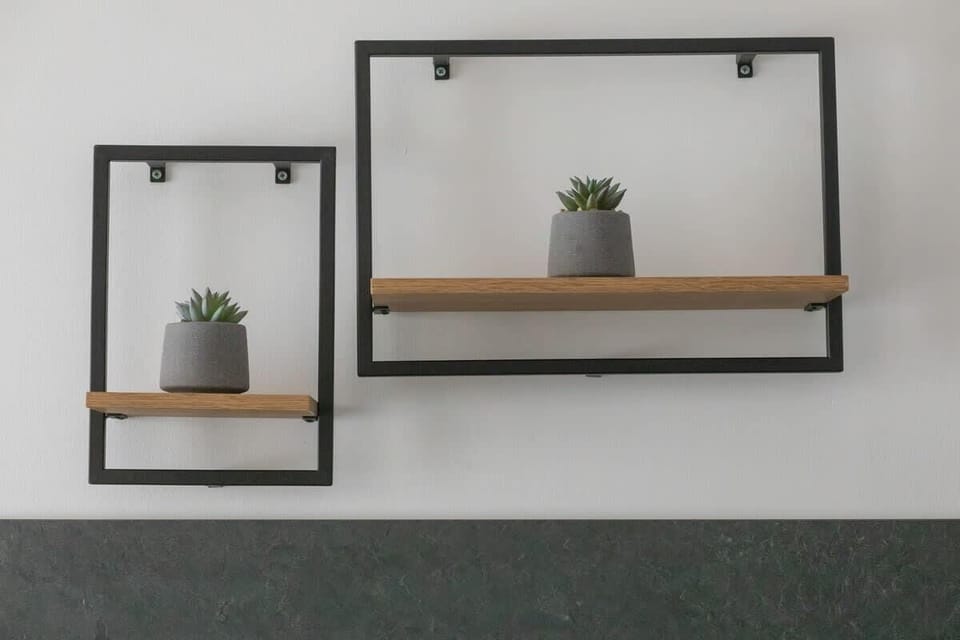 A decorative wall shelf with minimalist black frames and small plants, adding a stylish accent to the interior.

