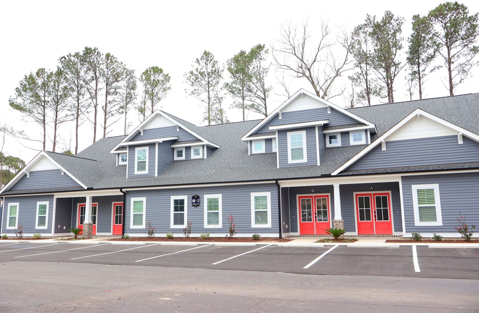 Newly built three-bedroom townhome with modern architecture, inviting front entrance, and beautifully landscaped surroundings.