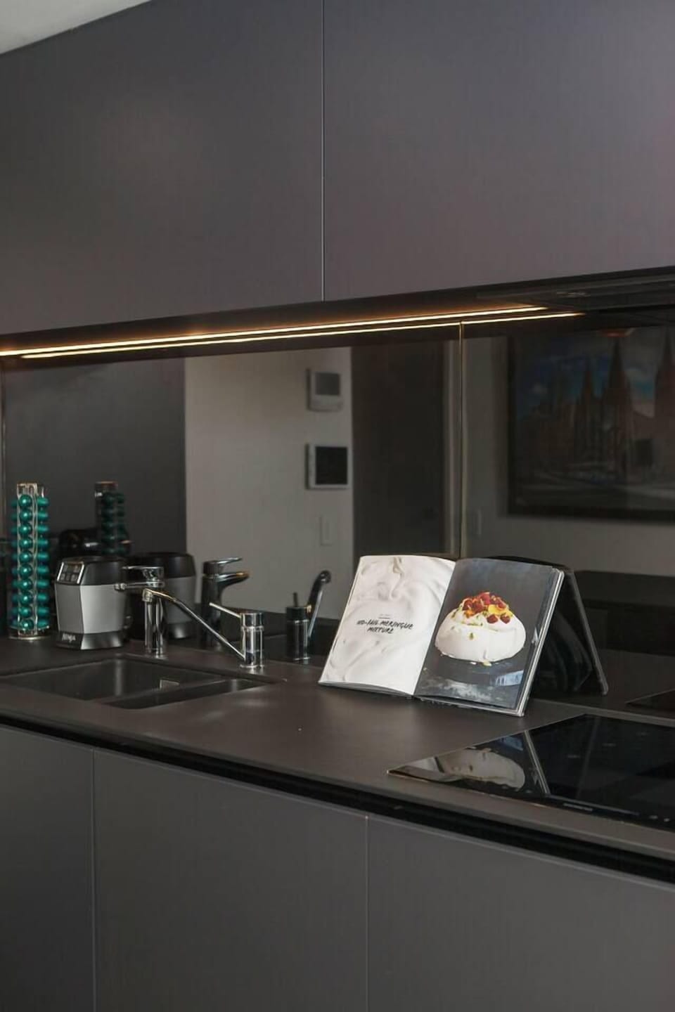 Sleek appliances in the kitchen include a coffee pod machine and blender.
