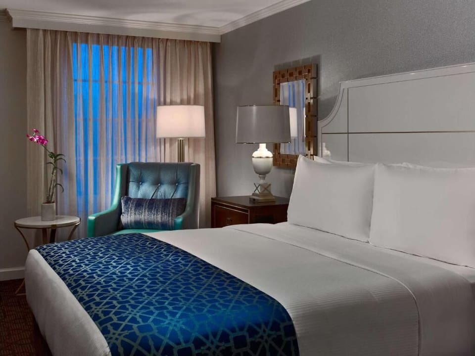 Drift off in crisp linens beside a relaxing reading chair.