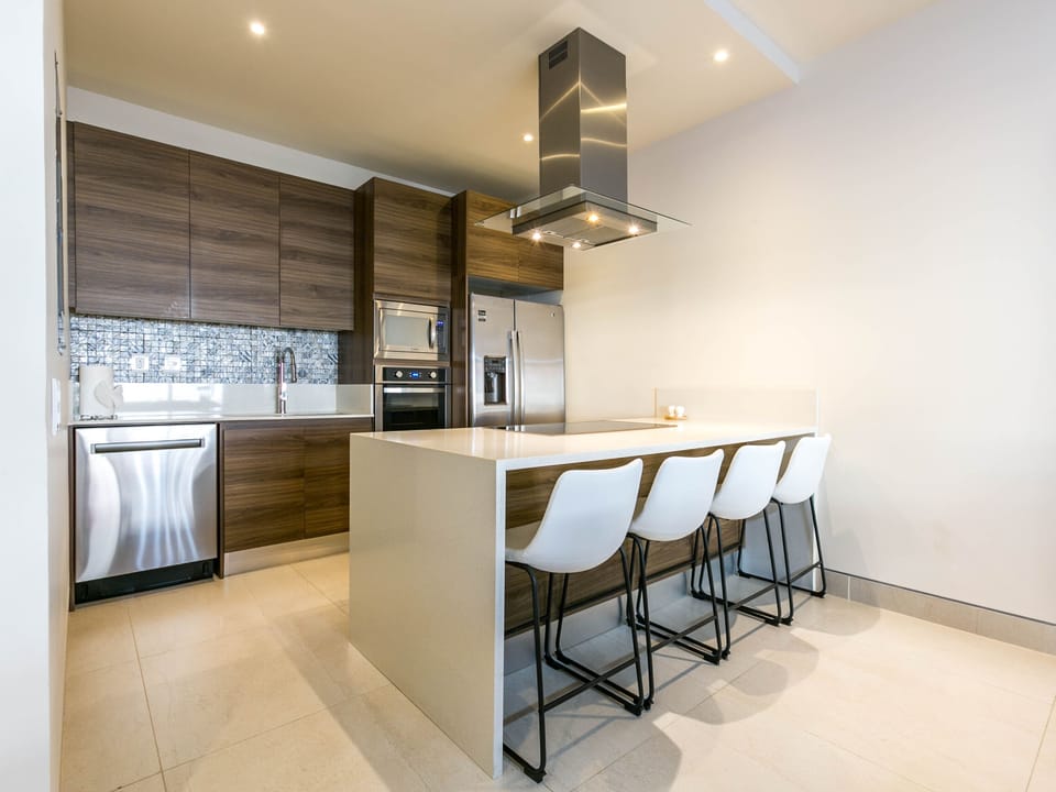 Step into the beautiful kitchen, equipped with modern appliances and ample counter space. Perfect for culinary enthusiasts, this kitchen boasts sleek finishes and a large refrigerator. Whether you're preparing a gourmet meal or a quick snack, you'll find everything you need to make your stay enjoyable. The adjacent sitting area is ideal for morning coffee or evening chats.