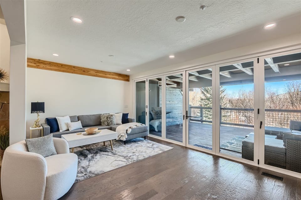 Unwind in this modern living space with an oversized sectional, large TV, and full sliding glass doors that open to mountain views and a private deck.