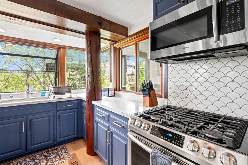 Cook w/ a view in this kitchen featuring a gas range, bold backsplash & big windows.
