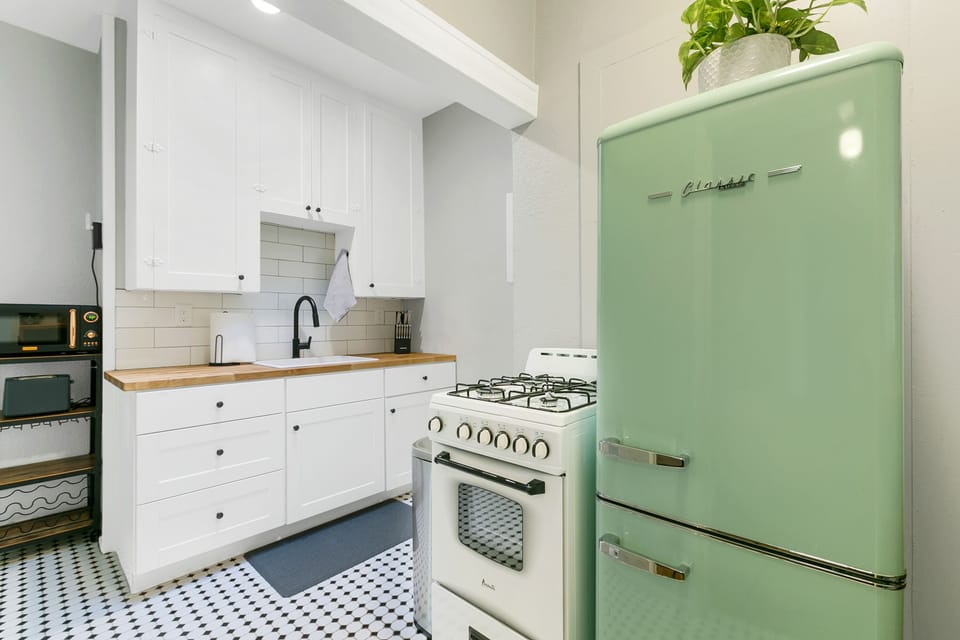 Your kichen with a small oven/stove and retro refrigerator.