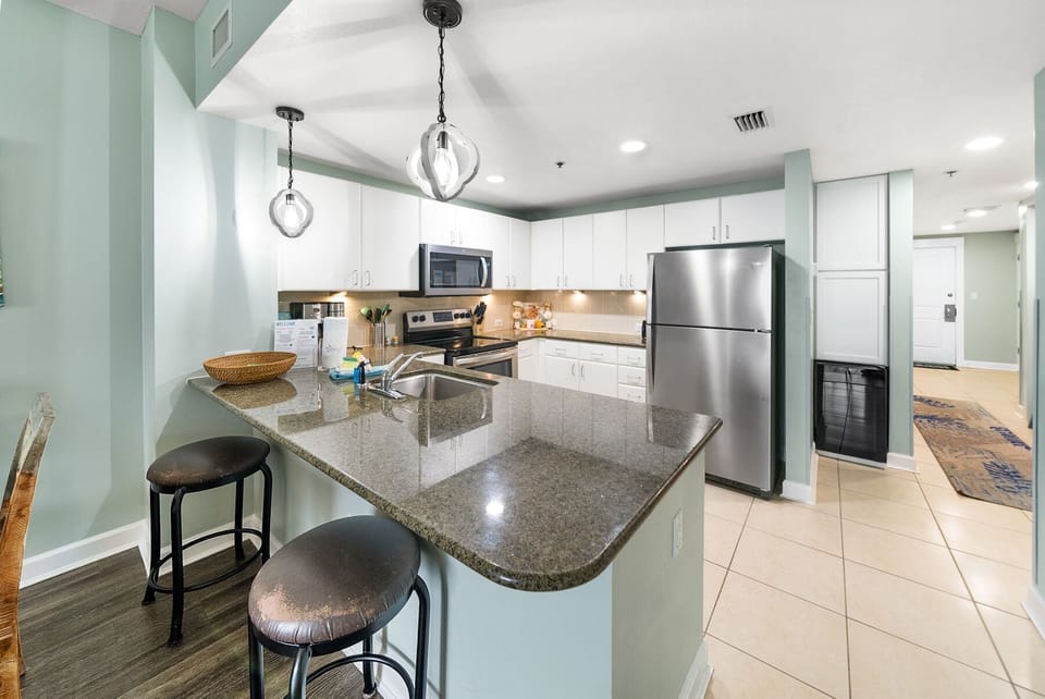 Your fully equipped kitchen features granite countertops, stainless steel appliances, and a breakfast bar where you can enjoy morning coffee.