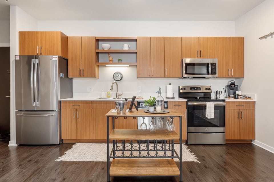 Full kitchen w/ stainless steel appliances, wood cabinets & handy prep island