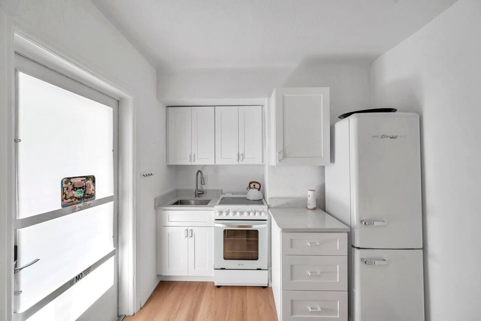 Clean, functional kitchen space w/ white finishes & natural light for everyday cooking.