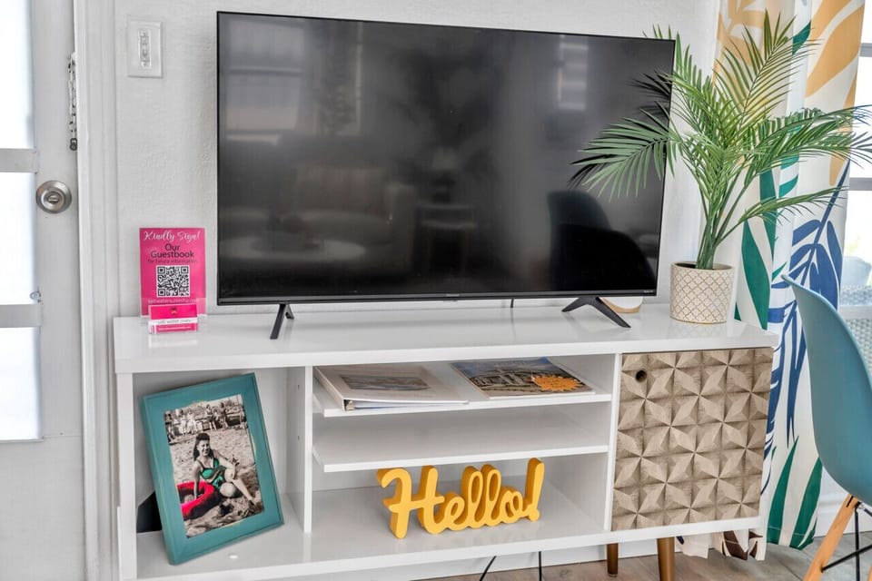 Media console w/ TV, coastal decor, and warm accents for relaxed movie nights
