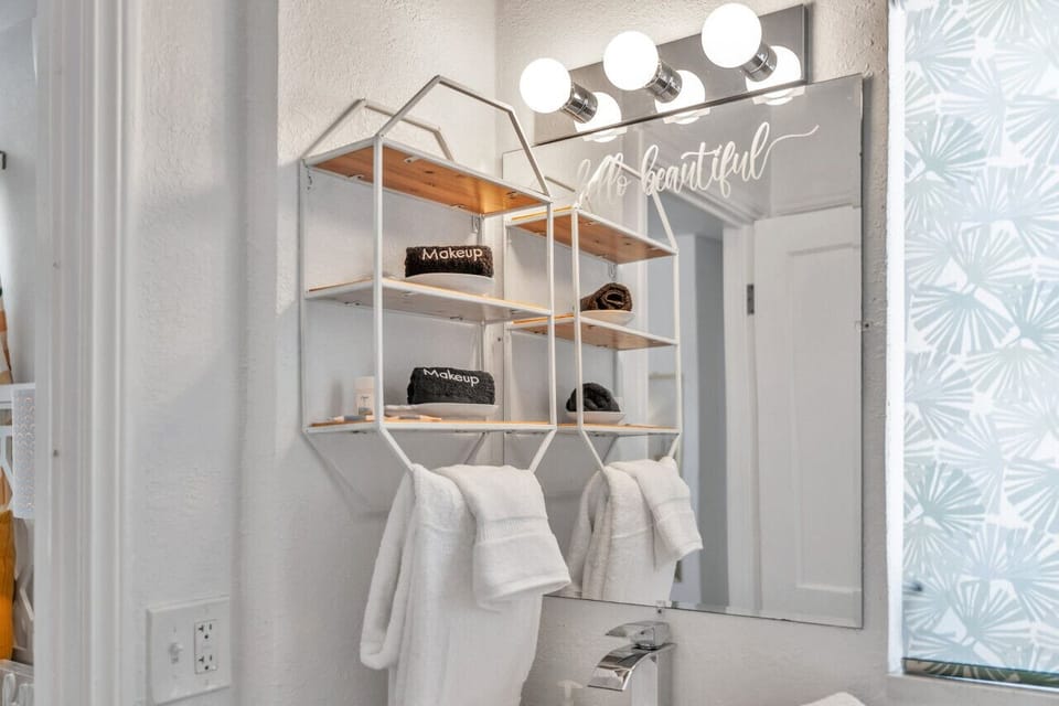 Bathroom w/ sink, hanging towels, and natural light creating a calm start to the day