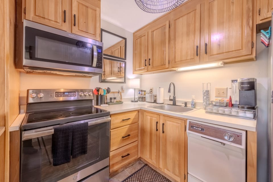 Fully stocked kitchen with appliances, plates, glasses, & utensils. 