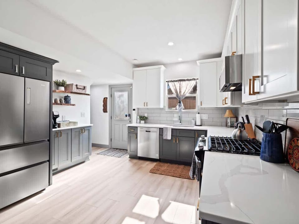 - Spacious kitchen with stainless steel appliances   - White and gray cabinetry with subway tile backsplash   - Modern countertops and open layout for cooking  
