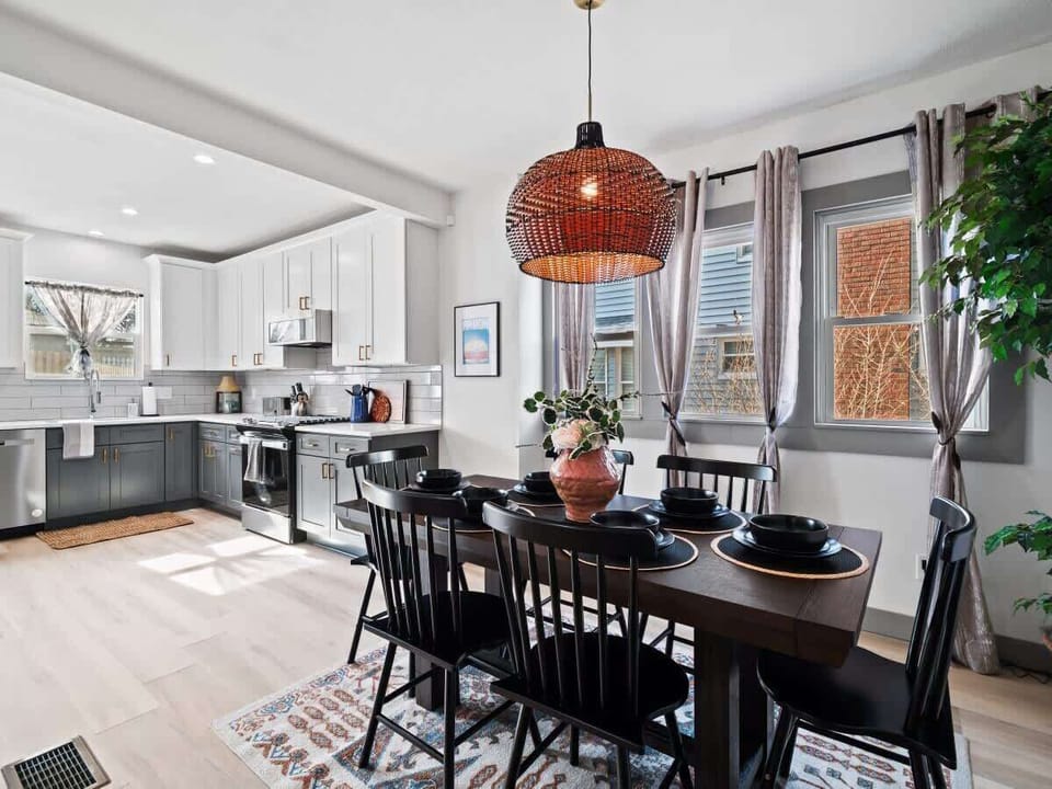 - Bright dining space beside modern kitchen layout   - Large windows bring in sunlight with flowing curtains   - Perfect for family meals and entertaining guests  