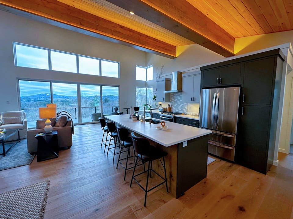 Lovely kitchen, dining, and living space on the main level with large windows and mountain views.