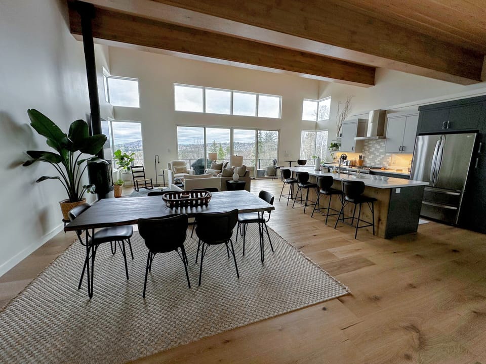 Lovely kitchen, dining, and living space on the main level with large windows and mountain views.