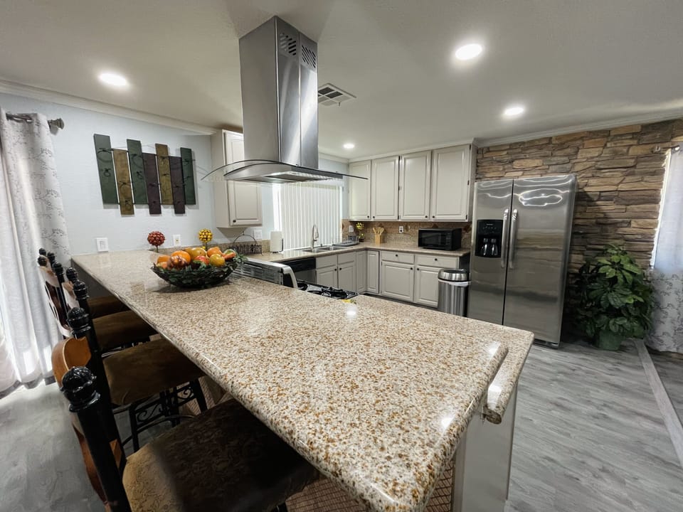 Granite countertops with high chair seating area.