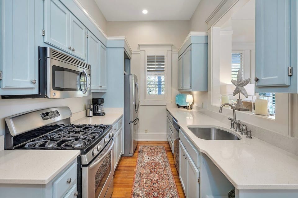 Kitchen with stainless steel appliances and blue cabinetry