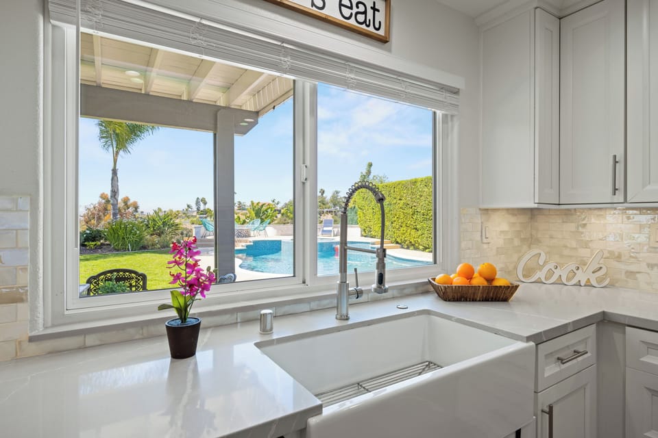 Enjoy poolside views from a bright, modern kitchen—your paradise starts here!