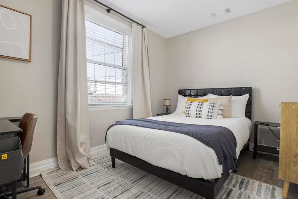 This bedroom features a cozy bed and workspace.
