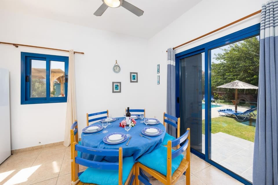 Open-plan living room with sofas, dining area, kitchen, A/C, WiFi internet, and satellite TV