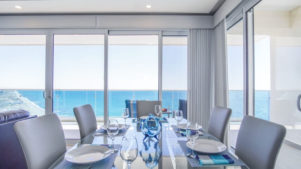 The dining table is set right where the two 'walls of windows' meet, creating a unique ambiance.