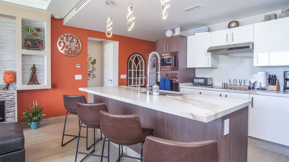 Bar stools at the kitchen island with custom lighting