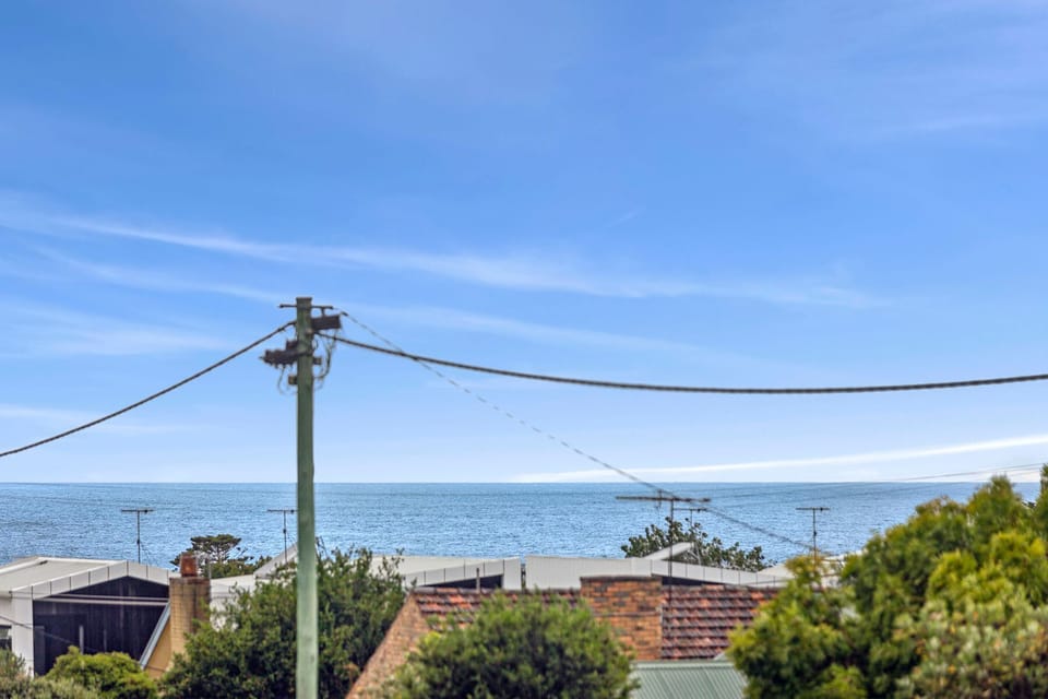 Ocean glimpses from the expansive living room windows let you check the day out