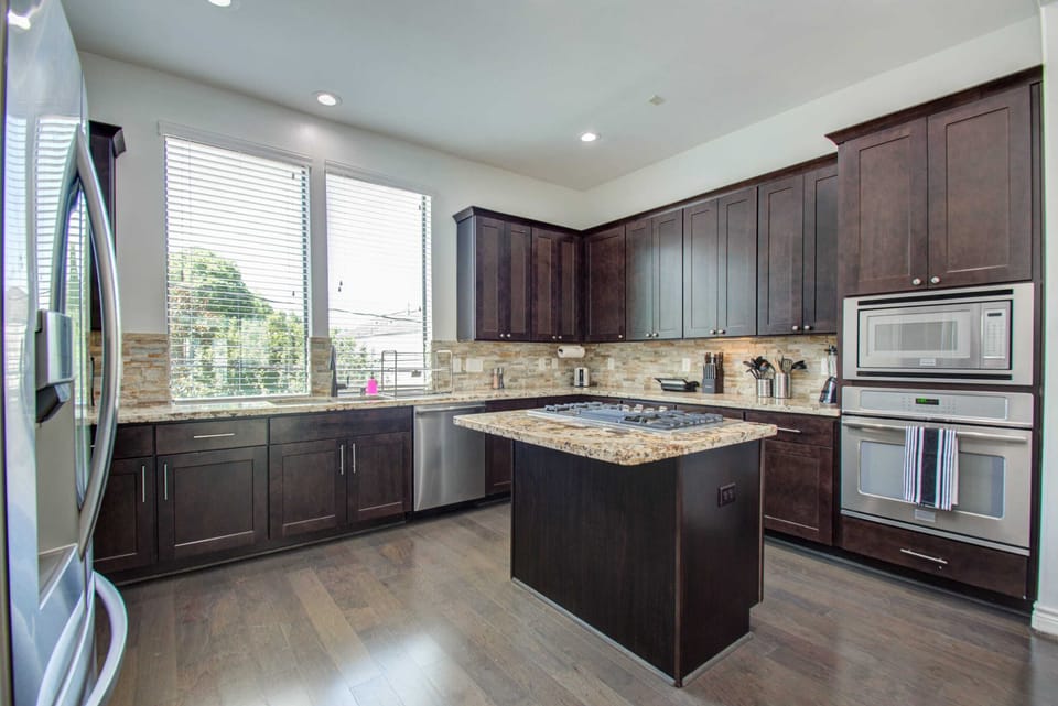Modern Gourmet Kitchen with Dark Wood Cabinets & Granite Island