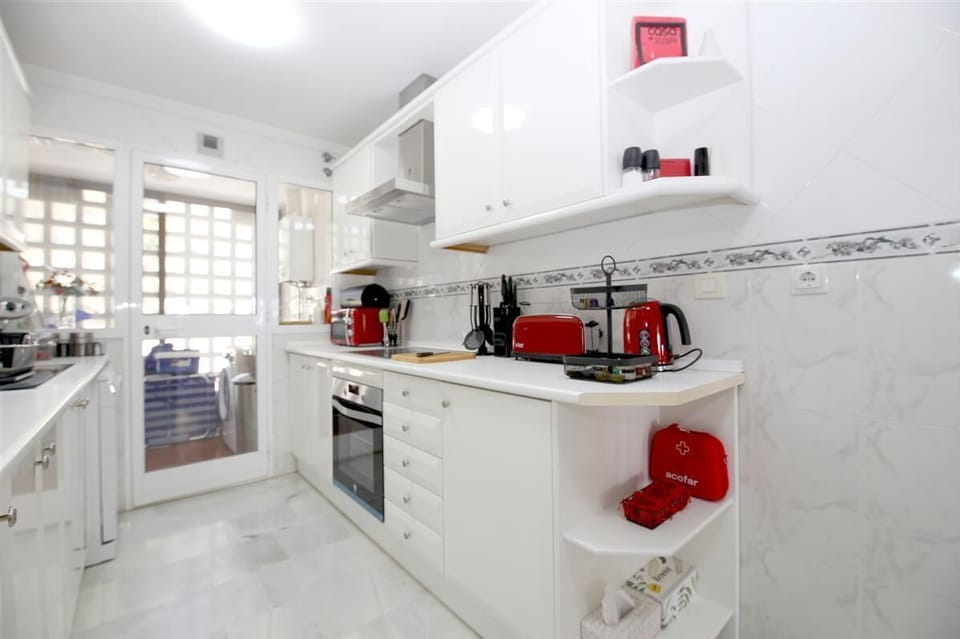 Kitchen in this apartment is fully fitted with all the appliances