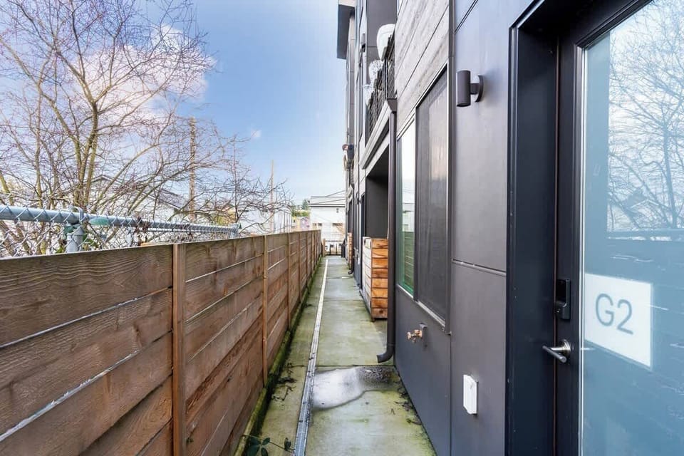 Clean, contemporary building entrance featuring a gated path, sleek design, and a calm residential feel.
