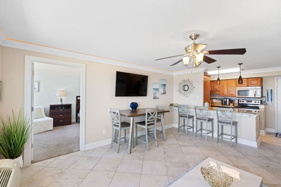 Open living and dining space with a full kitchen and bar seating, perfect for easy meals, game nights, and beachy downtime.