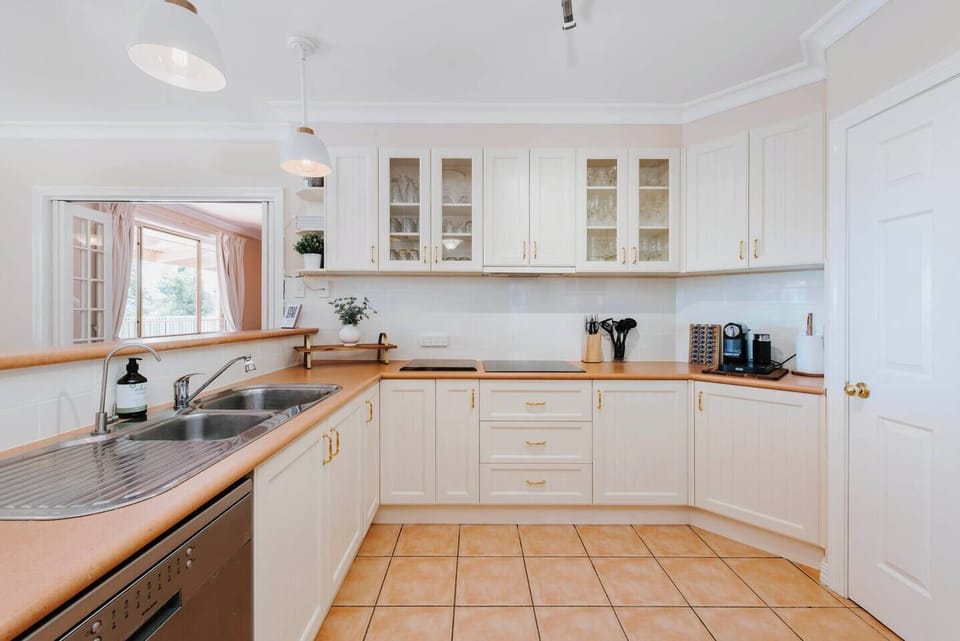 The kitchen features a contemporary induction stovetop, Nespresso coffee machine and wine glasses that are perfect for sampling some famous local drops.