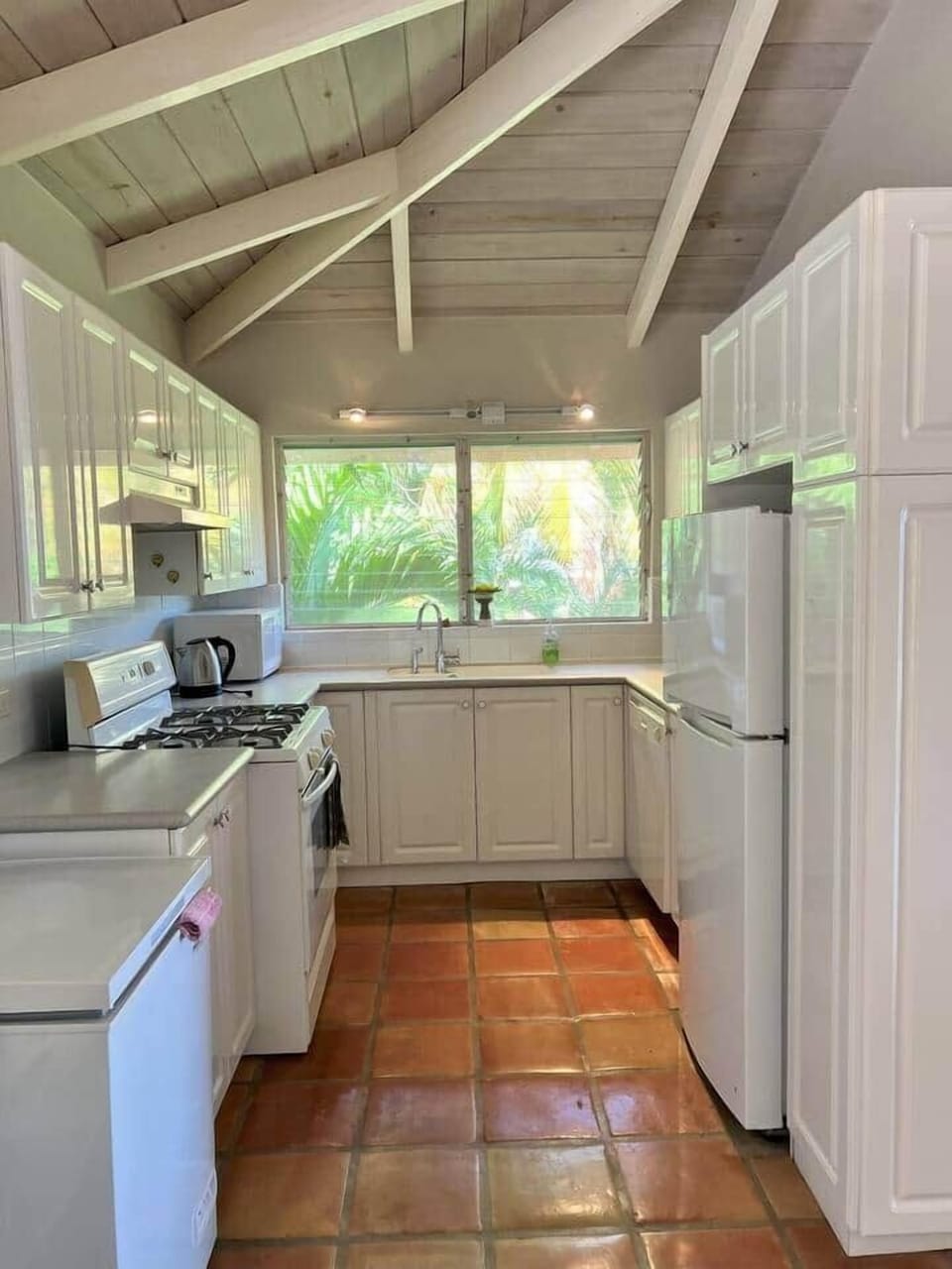 The image features a stylish upstairs apartment kitchen with elegant lighting that illuminates the space beautifully, creating a warm and inviting atmosphere.