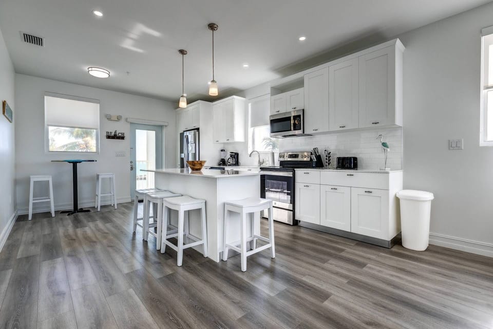 The expansive kitchen boasts abundant seating, creating a welcoming space for you to gather and enjoy delightful moments of culinary enjoyment.
