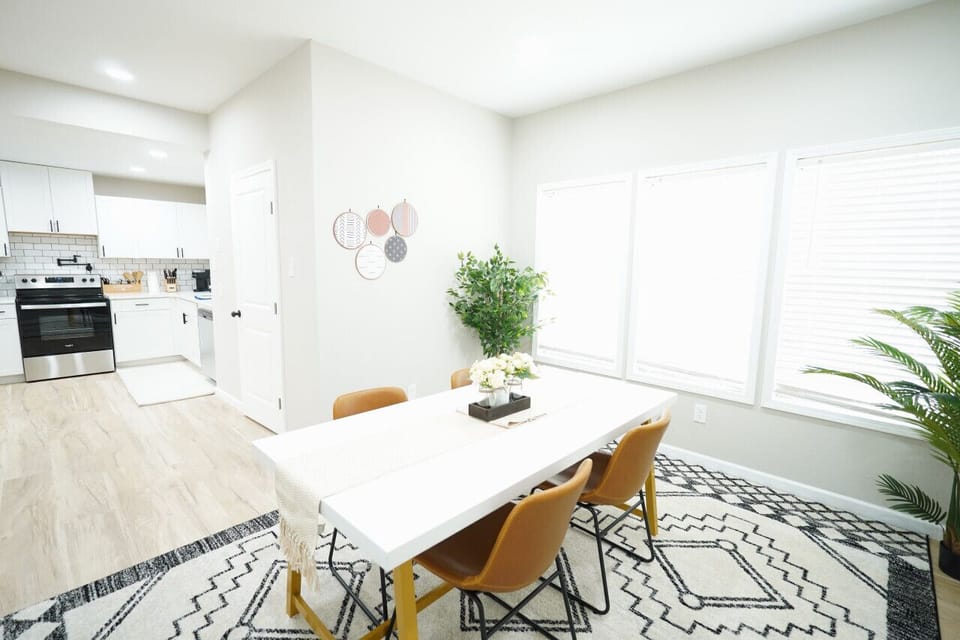 `Savor your meals in this bright and airy dining space, where natural light spills in to highlight the modern, clean lines of the decor. The fully equipped kitchen with stainless steel appliances beckons for culinary adventures, while the stylish dining t