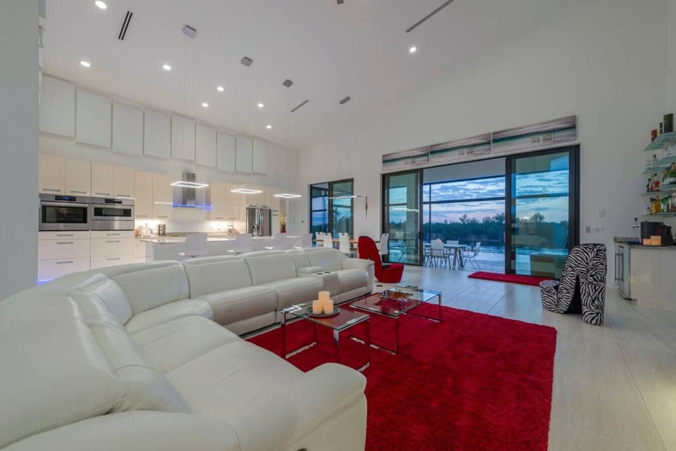 Open-concept living area with modern kitchen and stunning sunset views from the floor-to-ceiling windows.