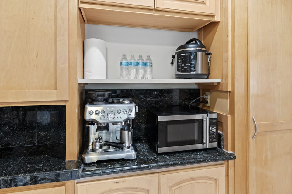 Kitchen counter: coffee maker, microwave, pot.
