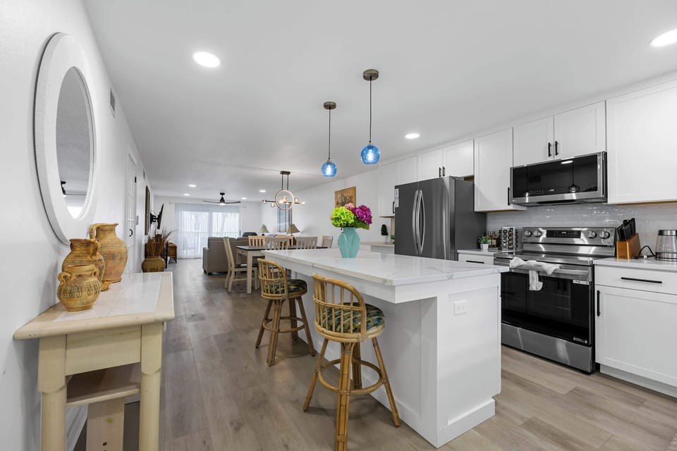 Open-concept kitchen and dining area with modern white cabinetry and stainless steel appliances