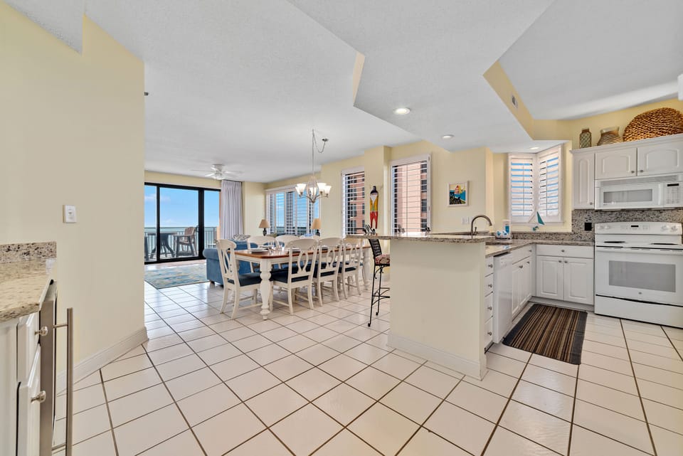 Dine in style with ample space for everyone. This inviting dining area features a charming table for family meals, complemented by additional seating at the convenient breakfast bar.