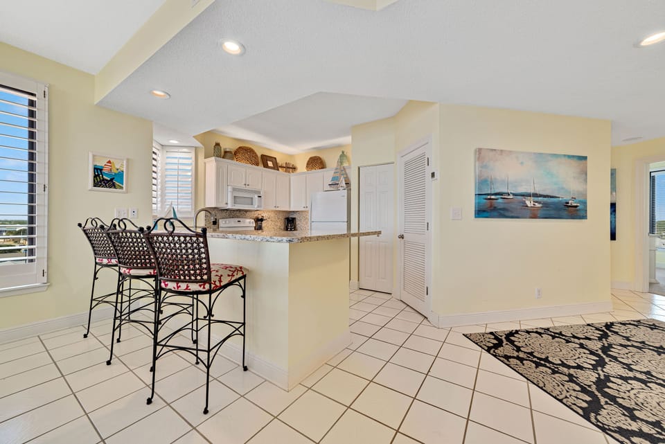 This beautifully designed kitchen boasts a spacious island with a contrasting stone countertop and stylish stools, creating a natural hub within the home.