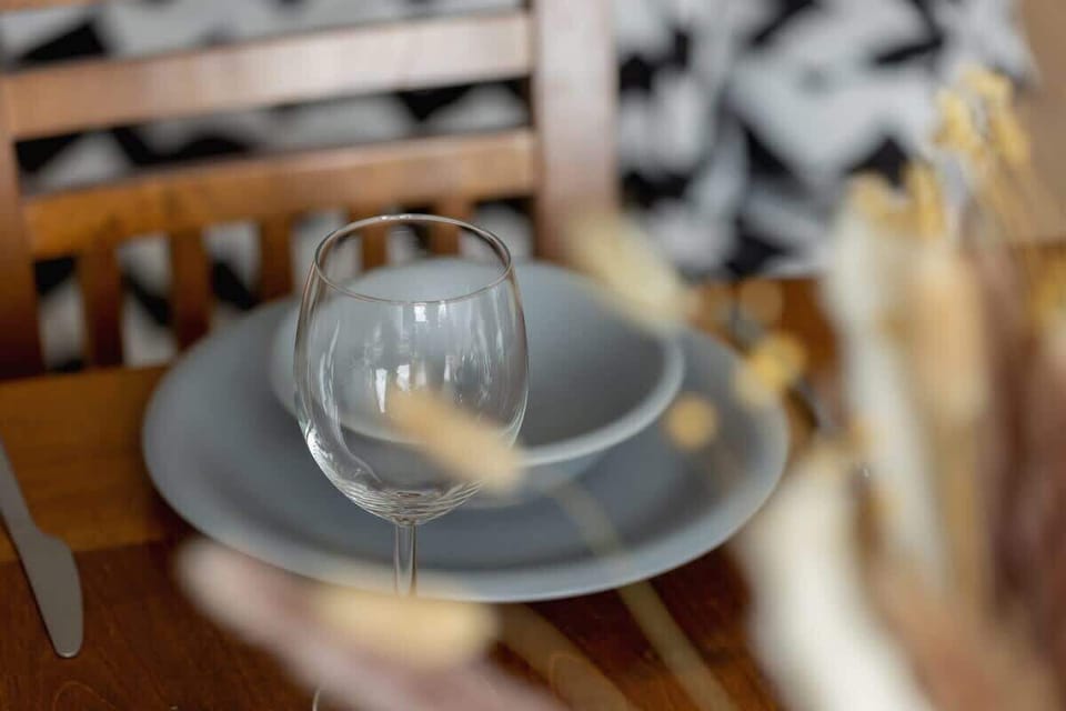 A close-up of the dining table place setting, featuring a gray plate, matching cutlery, and a decorative napkin.

