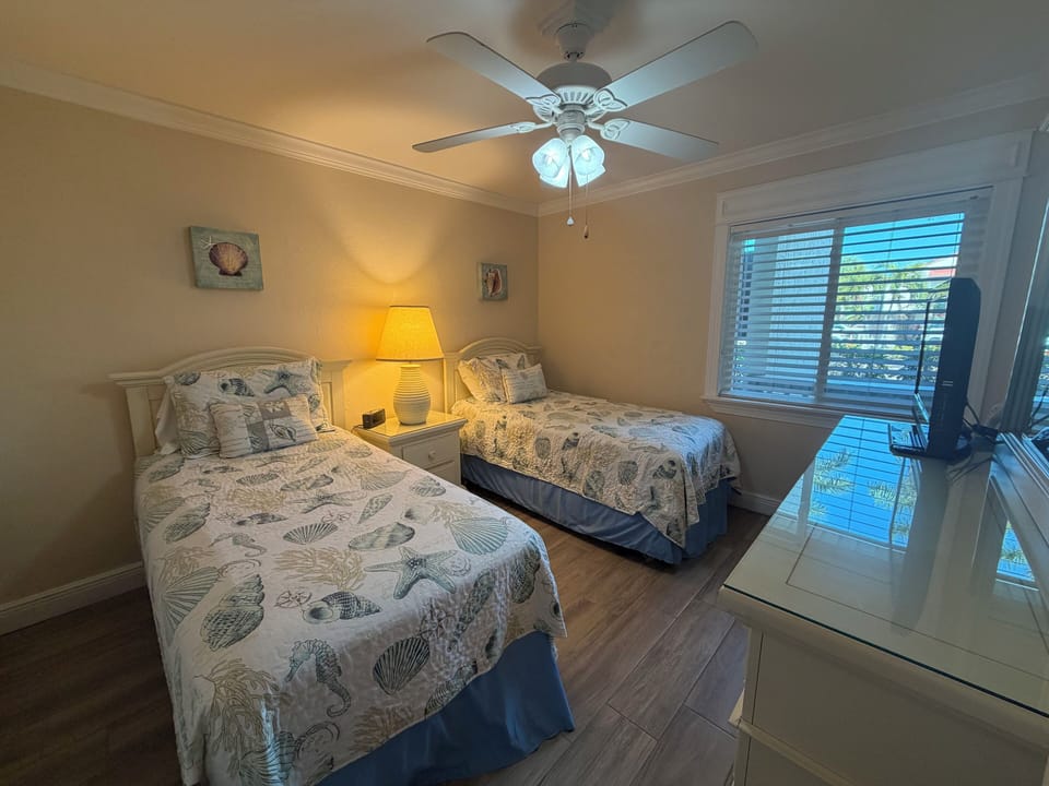Your peaceful twin bedroom features coastal bedding and gentle ceiling fan breezes for restful nights.