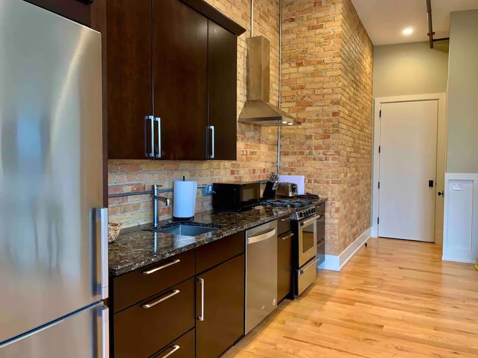 Kitchen features a gas range, dishwasher, microwave, toaster, Kuerig and refrigerator.
