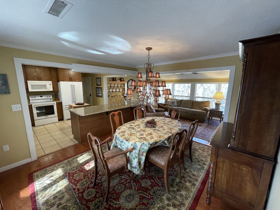 Dining room is the center of the kitchen, den and breakfast room so much light