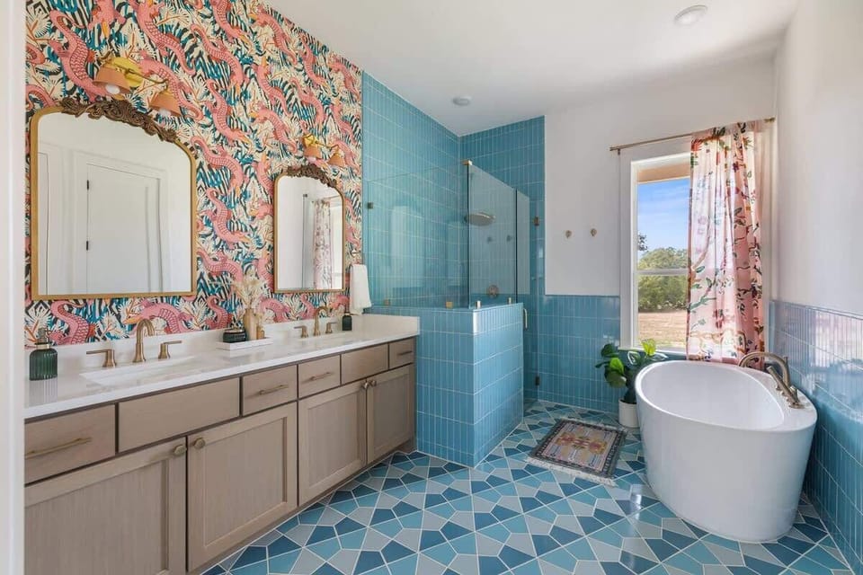 En suite bathroom in primary bedroom downstairs features double sinks, walk-in shower, separate soaking tub, and a walk-in closet. 