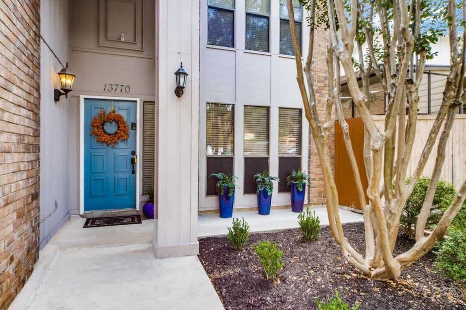 Charming front entrance with a bright pop of color, welcoming décor, and thoughtful landscaping to make you feel right at home from the moment you arrive.