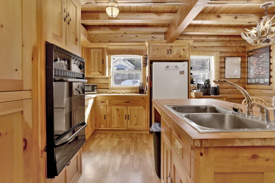 Fully equipped cabin kitchen with ample cabinetry, stove, fridge, microwave, and coffee maker—perfect for cooking meals, morning coffee, and feeling right at home on your stay.