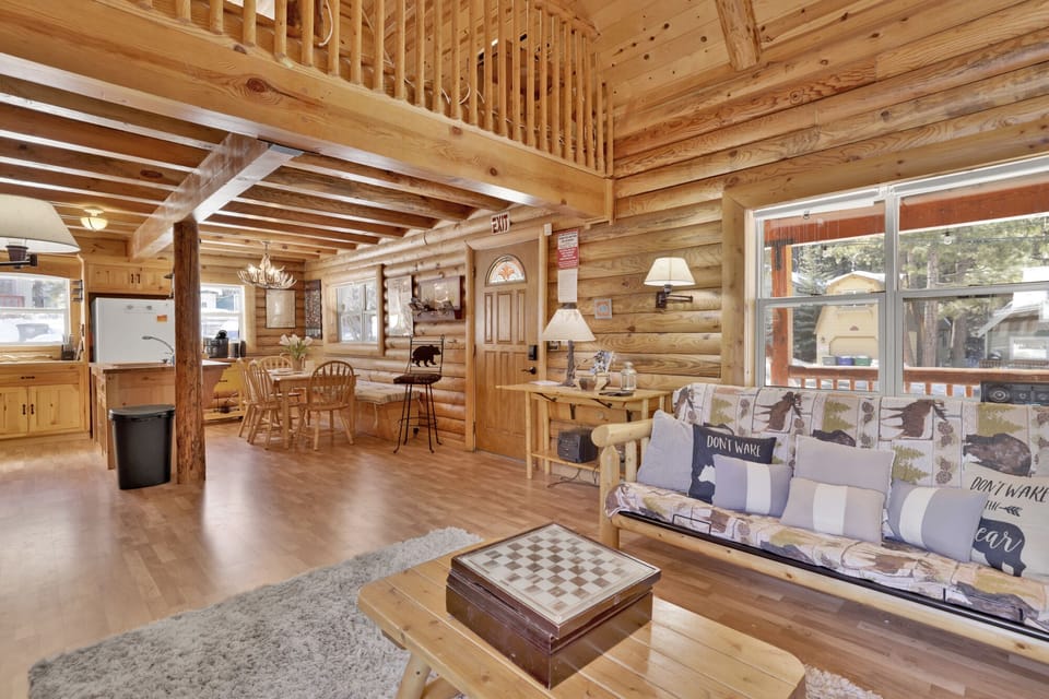 Cozy mountain living room with a stone fireplace, comfy seating, and smart TV—perfect for relaxing evenings, movie nights, and warm cabin vibes after outdoor adventures.