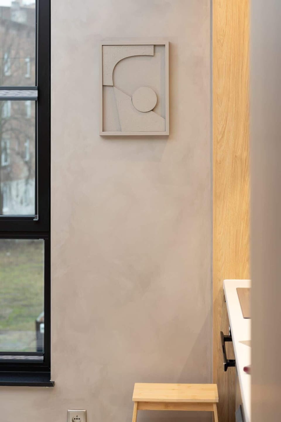 A textured wall with a small, framed decoration, adding an artistic element to the apartment's interior.

