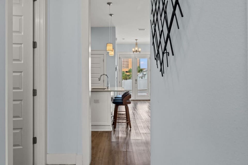 Step through the inviting hallway leading to the outdoors, where the coastal breeze beckons and relaxation awaits
