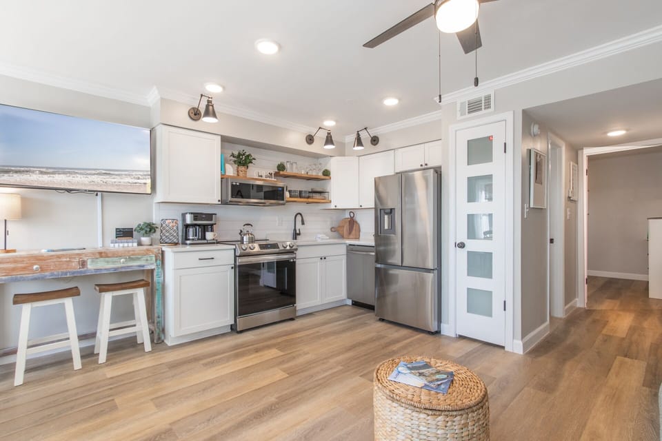 Enjoy cooking in this updated kitchen with open shelving, stainless appliances, stone countertops, and charming ship lap detailing.